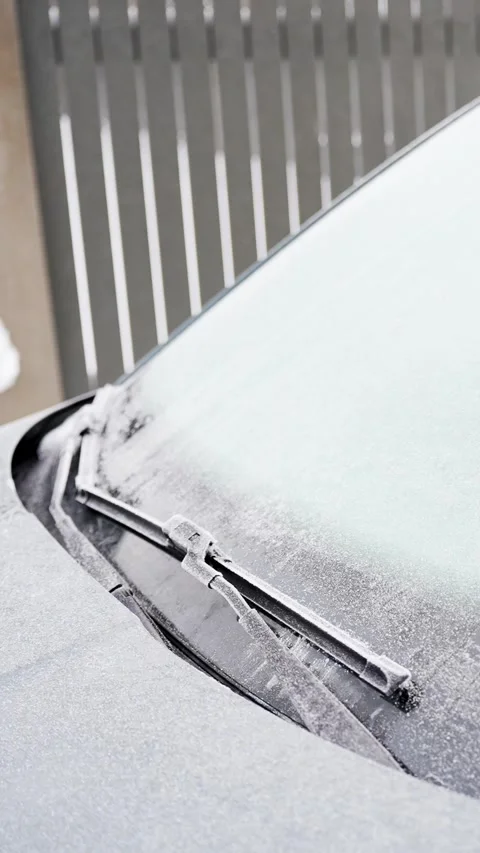 Close-up of a windshield wiper frozen under snow and frost on a parked car Stock-Footage 327889653