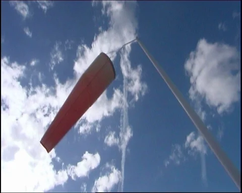 Close-up of windsock blowing in breeze silhouetted against cloudy sky, bright 動画素材 95608671
