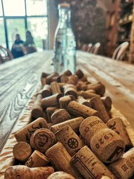 Close-up of wine corks on a wooden table and a glass bottle in the background Stock Photos
