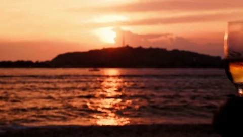 Close up of wine glasses clinking in front of ocean sunset Stock Footage 78661697