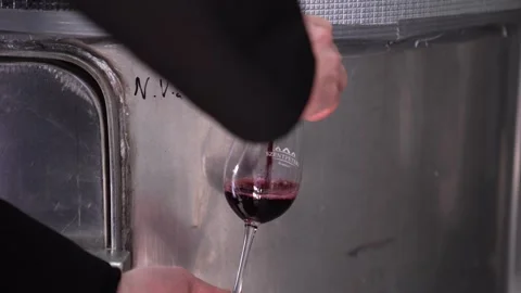 Close-up of wine pouring into glass from fermentation tank for tasting Stock Footage 310334812