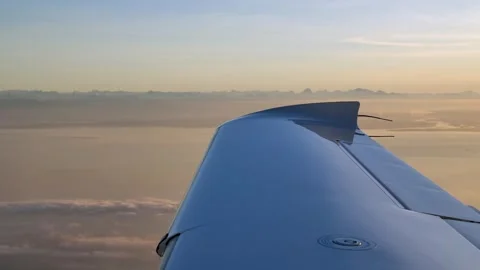 Close Up Wing Tip of Flying Airplane with Golden Hour Sky and Clouds Stock Footage 303892452
