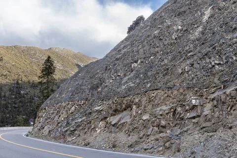 Close-up on wire mesh grid installed on slope to stabalize the soil and prevent Stock Photos