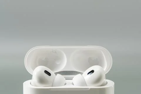 Close up of wireless earbuds seated in an open charging case. Stock Photos