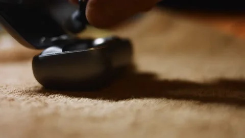 Close-up of wireless earphones in the charging case. Male's hand puting the Stock Footage 144937057