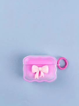 Close up of wireless headphone case with cute bow on table Stock Photos