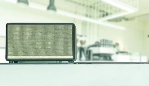 Close-up wireless speaker, luxury high-end music gadget in the cafe. on a g.. Stock Photos