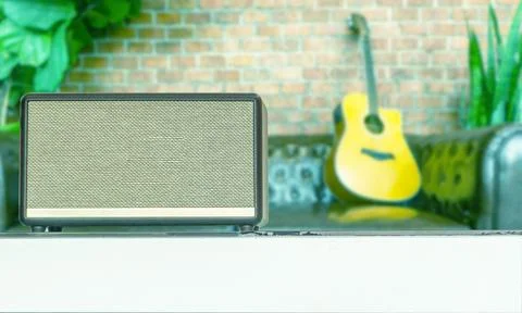 Close-up wireless speaker, luxury high-end music gadget in the cafe. on blu.. Stock Photos