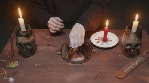Close up of witch female fortune teller pours rice on the mirror and painted Stock Footage 145684447