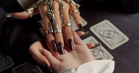 Close-up of witch reading clients palm during fortune-telling ritual Stock Footage 320007707