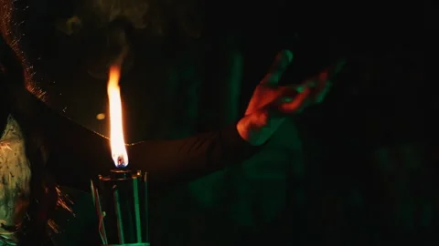 Close-up of a witch's hand on a burning torch flame. Stock Footage 286087257