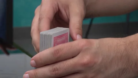 Close-up of a withe hands of a man shuffling playing cards and using his knees Stockbeeldmateriaal 155815327