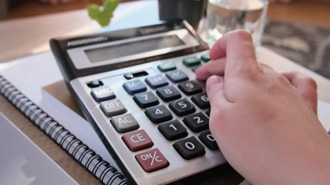 Close up woman accountant working using calculator and laptop, statistics on Stock Footage 230214730