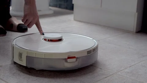 Close Up of Woman Activating Smart Robot Vacuum Cleaner at Home Stock Footage 338412976