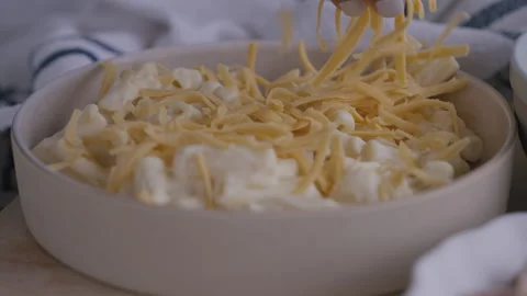 Close-up of woman adding cheddar to macaroni and cheese in plate 스톡 동영상 254888909