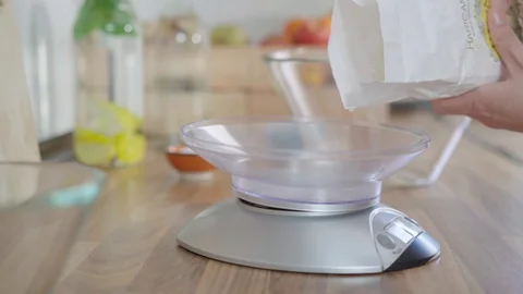 Close up of a Woman adding flour to an electronic weight to make pizza dough  Stock Footage 128201867