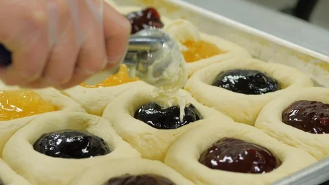 Close up of woman adding fruit and cream cheese filling to kolache dough Stock Footage 93371924