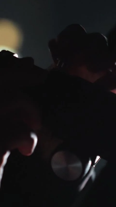 Close up of woman adjusting camera settings in dark environment with blurred Stockbeeldmateriaal 346239782