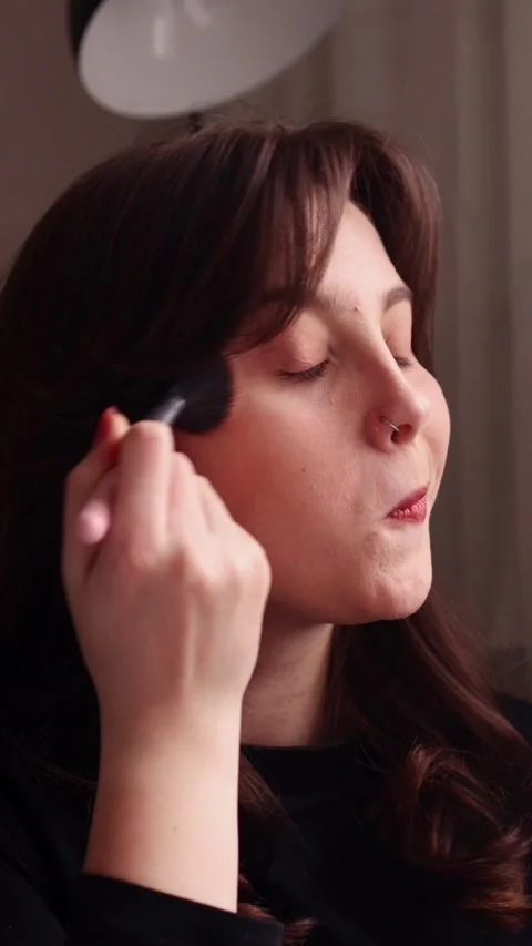Close-up of woman applying blush to cheeks with makeup brush Stock Footage 328577330