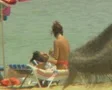 Close up of woman applying sun lotion to man on sun lounger SD Footage