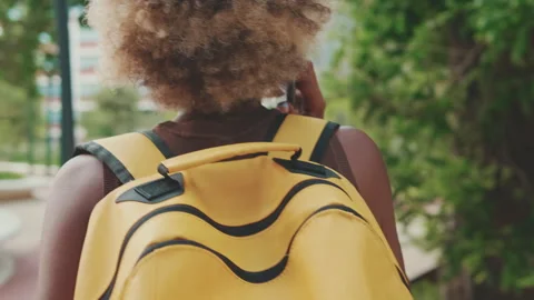 Close up, woman with backpack talking on mobile phone while walking down the Video stock 255505689