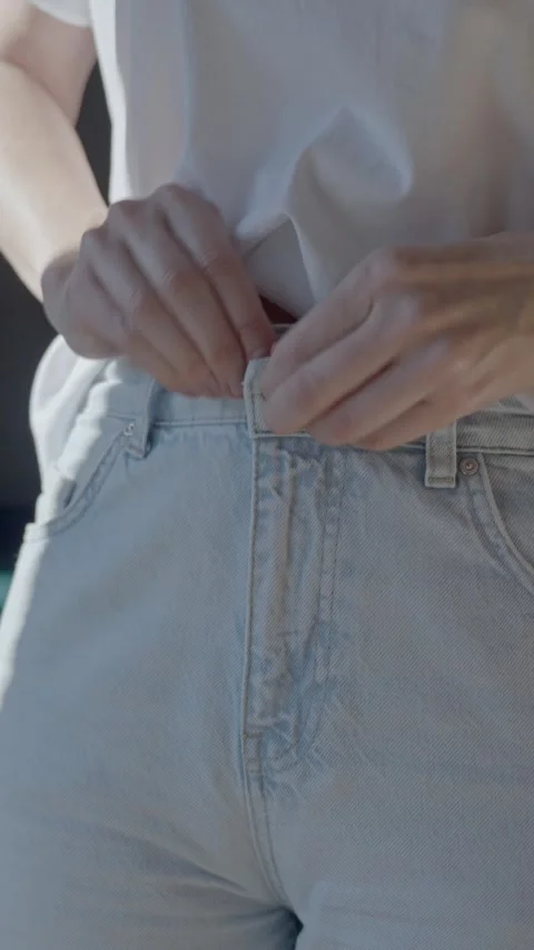 Close up of woman buttoning light blue jeans. Concept of casual dressing Stock-Footage 331315278