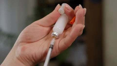 Close-up of a woman dialling the right dose of insulin into a syringe. Stock Footage 299903522