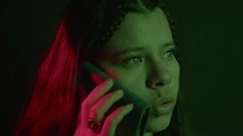 Close-Up of Woman in Dramatic Light Making a Phone Call Stock Footage 321203050