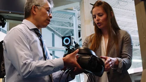 Close up of woman explaining features of VR gear to colleague Stock Footage 221037769