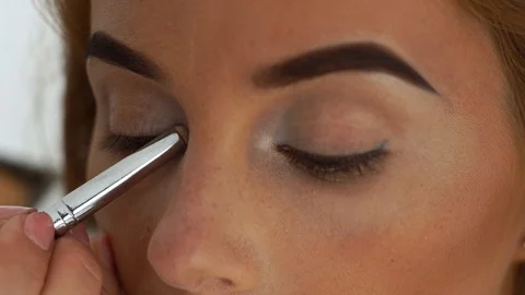 Close up woman face while applying eyes makeup with cosmetic brush in beauty Video stock 91431461