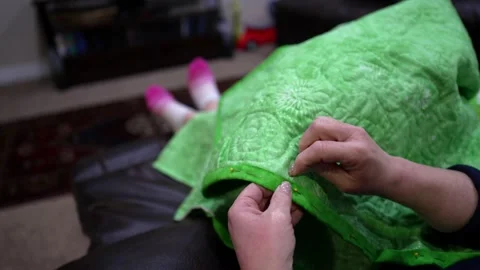 Close up of a woman hand stitching on the binding to a new quilt Stock Footage 171453598