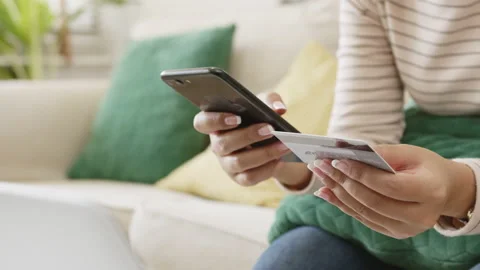 Close up woman hand using mobile phone and credit card to make payment Stock Footage 134363792