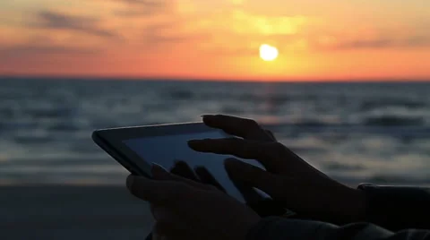 Close up woman hand using tablet at seaside on sunlight and background during Stock Footage 61218945