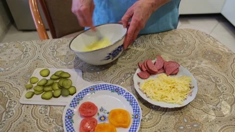 Close up of woman hands beating eggs in a bowl on kitchen table. Video stock 169798970