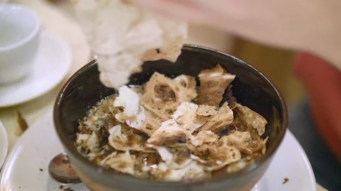 Close up of woman hands crumbling dry lavash into bowl with beef soup. Up view Stock Footage 127166370