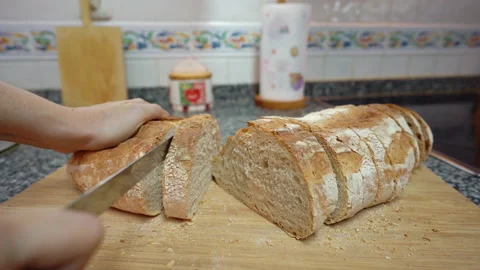 Close up of woman hands cutting a rustic bread over a wooden board Stock Footage 163602801
