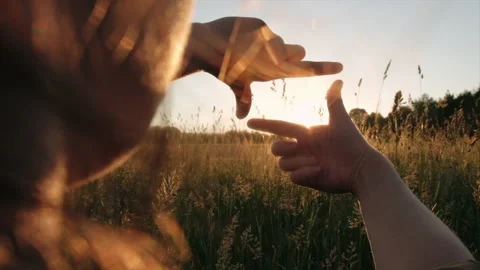Close up of woman hands making frame gesture on background beautiful calm sunset Vidéo 199375086