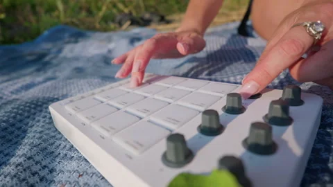 Close Up of Woman Hands Turning Knobs on White Midi Controller Outdoors Stock Footage 342771235