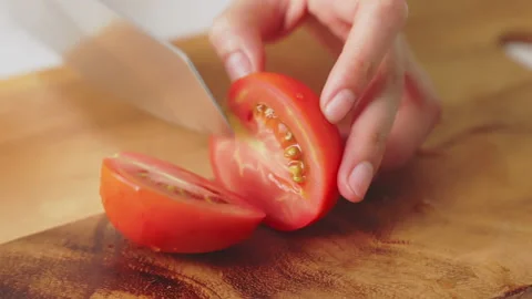 Close up of woman hands using kitchen knife cutting fresh tomato on wooden. 스톡 동영상 153961217
