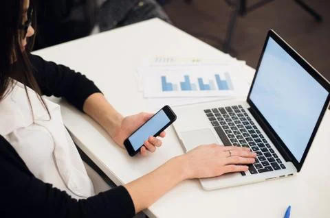 Close Up of woman hands using mobile phone and laptop computer with blank copy Stock Photos