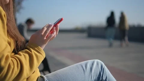 Close up of woman hands using a smart phone searching content on the street. 4K Stock Footage 252873984