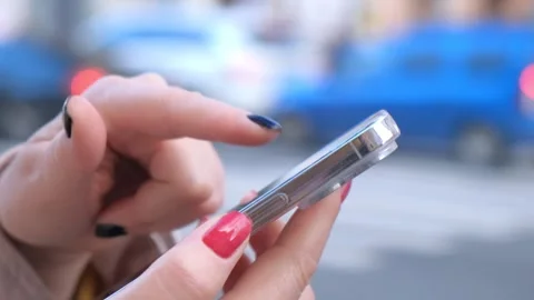 Close up of woman hands using a smart phone searching content on the street Stock Footage 276180750