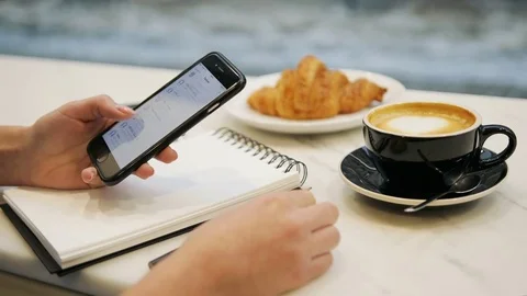 Close up of woman hands using smartphone, scrolling contacts and drinking coffee Stock Footage 72361749