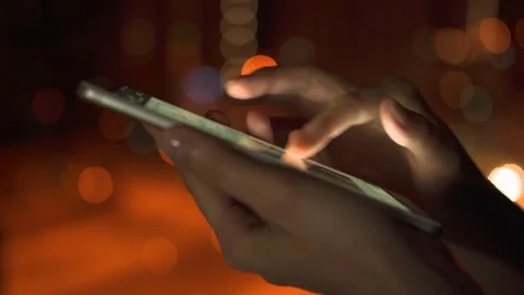 Close-up of woman hands using smartphone touchscreen outdoors in city at night Video stock 85574170