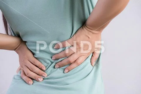 Close up woman having pain in injured back. Healthcare and back pain concept. Stock Photos