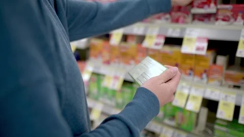 Close up of a woman  hold two boxes, choosing medication at drug store. Healt 動画素材 274112475