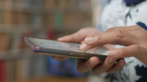 Close up of woman holding and using smart mobile phone, scrolling browsing in Stock Footage 141885953