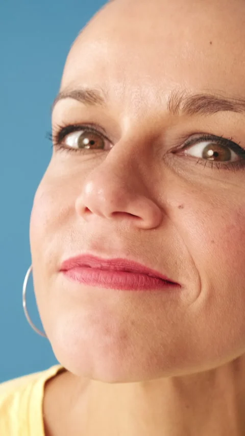 Close-up of woman looking at the camera looking for something, standing on blue Stock Footage 298638236