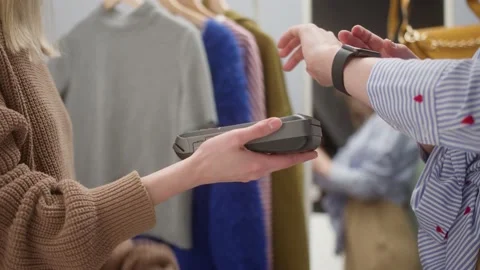 Close-up of woman making payment using nfc in showroom, fashion clothes store Stock Footage 149996537