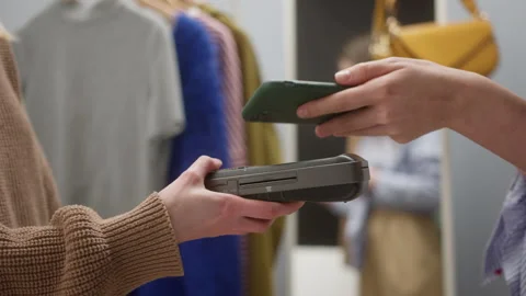 Close-up of woman making payment using nfc in showroom, fashion clothes store Stock Footage 150110189